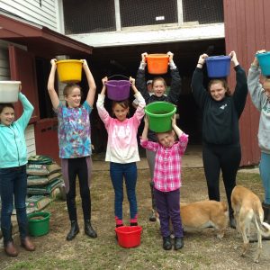Hands-on feed pail cleaning by youth.