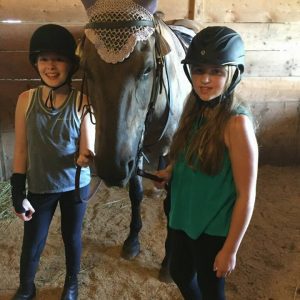 two kids and fendler in stall ready to ride